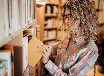 Woman searching for book in library